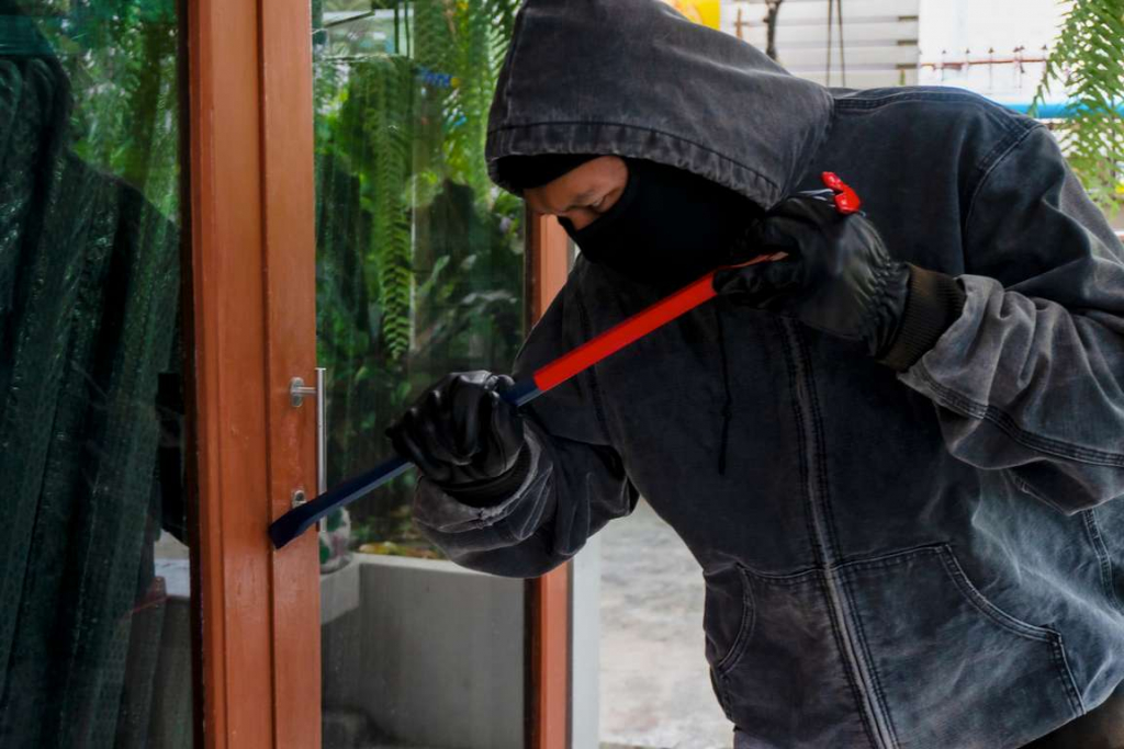 Burglar breaking into house with a crowbar, make sure you are burglar proofing your property