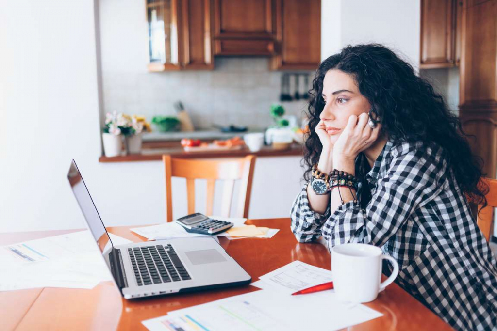 Woman looking at her laptop trying to figure out how to hire a private investigator to track down a loved one